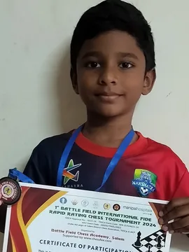 A student holding a participation certificate and medal from a FIDE rapid rating tournament